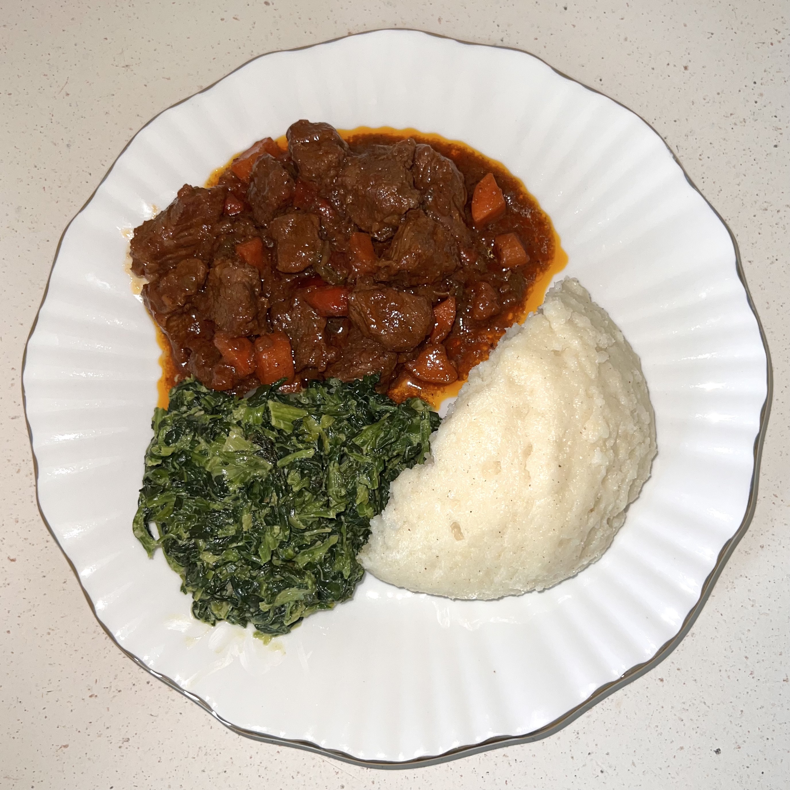 Ugali, beef stew, and creamed spinach