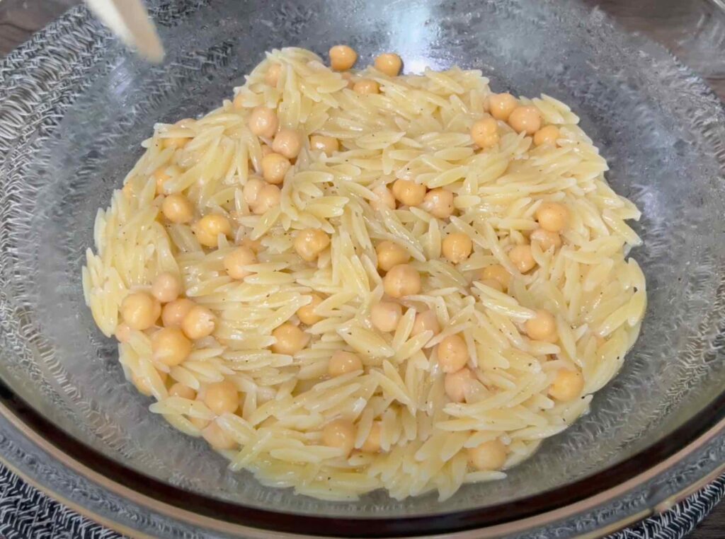 Orzo and chickpeas soaking up salad dressing
